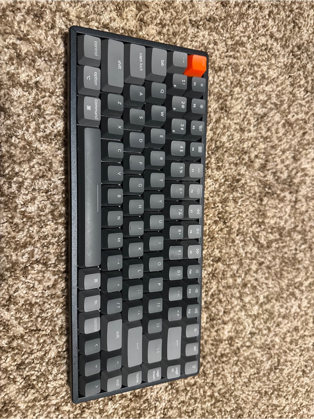 Compact Gray Mechanical Keyboard with Orange Accent Key